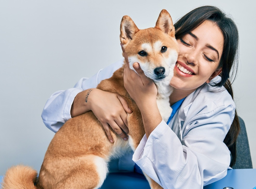 a person in white lab coat holding a dog